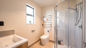 A modern bathroom with a glass-enclosed shower, a toilet, a sink, and a window with a plant. - peaceful /warm /family friendly /2bedroom2bathroom/kingbed/unitB (Lake Tekapo)