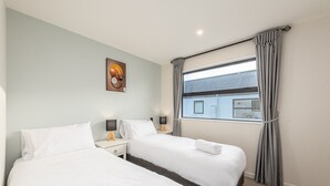 A hotel room with two beds, a window with curtains, a wall-mounted picture, and a small bedside table with a lamp. - peaceful /warm /family friendly /2bedroom2bathroom/kingbed/unitB (Lake Tekapo)