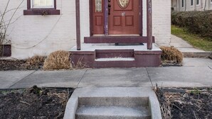 A building with a prominent entrance featuring a wooden door with a star decoration above it. - Charming, historic 3-bedroom house in quaint Fredericksburg with AC, WiFi (Fredericksburg)