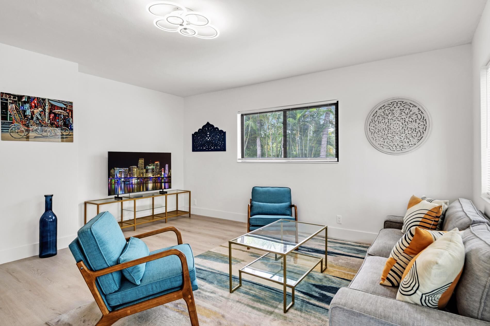 Een moderne woonkamer met een bank, fauteuil, salontafel en kunstwerken aan de wanden.