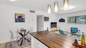 A modern kitchen with a wooden countertop, clear chairs, and pendant lights. - Modern 2/1 rent near Las Olas Fort Lauderdale (Fort Lauderdale)