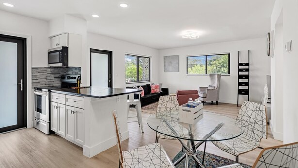 A modern kitchen with white cabinetry, a built-in microwave, and a large island with seating. - Rent 2/1 in Fort Lauderdale near Las Olas (Fort Lauderdale)