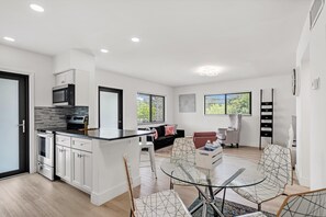 A modern kitchen with white cabinetry, a built-in microwave, and a large island with seating. - Rent 2/1 in Fort Lauderdale near Las Olas (Fort Lauderdale)
