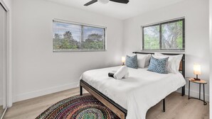 A bedroom with a bed, two bedside tables with lamps, a ceiling fan, and windows with blinds. - Rent 2/1 in Fort Lauderdale near Las Olas (Fort Lauderdale)