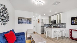 Een modern appartement met een woonkamer, keuken en een eethoek.
