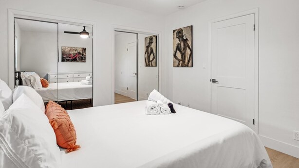 Een hotelkamer met een groot bed, een spiegel en kunstwerken aan de wanden.