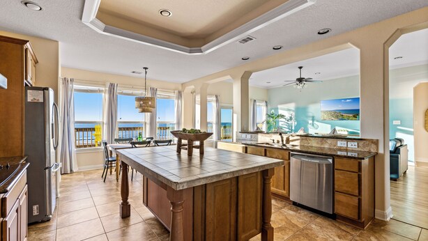 A spacious kitchen with a large island, modern appliances, and a view of the ocean. - Spacious Getaway | Gulf Views & Gameroom Fun (Gilchrist)