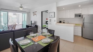 Una cucina moderna con mobili bianchi, un forno a microonde e un frigorifero.