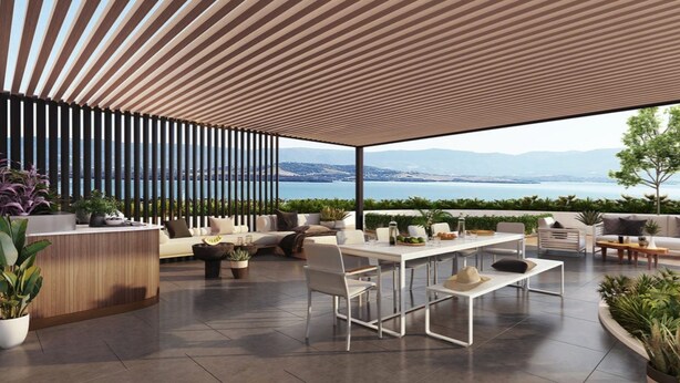 Un patio moderno al aire libre con comedor, asientos y vista al mar.