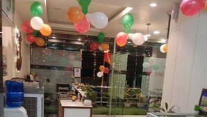 A room with a reception desk, a fish tank, and balloons. - Gatsby Hotel Jaipur (Jaipur)