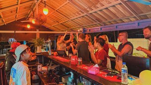 Eine Bar mit Holzbalkendecke, einer Theke und verschiedenen Barutensilien und Flaschen.