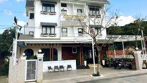 A multi-story building with a sign reading 'Sans Souci.' - Vô Tư Hotel (Xuan Huong - Da Lat)