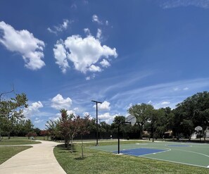 An outdoor basketball court with a clear sky, trees, and a pathway. - Downtown Dallas Modern CHIC Style 1Bed Abode (Dallas)