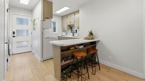A modern kitchen with a white countertop, two bar stools, and a built-in oven. - Peaceful Prescott Cabin Near Goldwater Lake (Prescott)