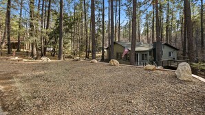 A cabin in a forest with a gravel driveway and large rocks. - Peaceful Prescott Cabin Near Goldwater Lake (Prescott)