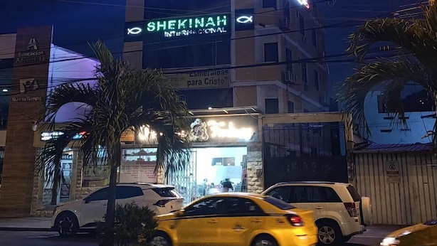 A hotel with a neon sign, a visible entrance, and a palm tree in the foreground. - HOTEL SHEKINAH INTERNACIONAL (Esmeraldas)