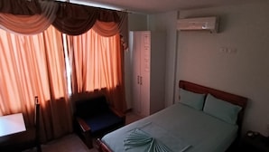 A bedroom with a bed, a desk, a chair, and an air conditioning unit. - HOTEL SHEKINAH INTERNACIONAL (Esmeraldas)
