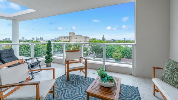 A balcony with seating, a coffee table, and a potted plant. - Charming 2-bedroom apartment with AC, fitness room in Hollywood (Hollywood)