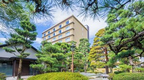 A modern building with multiple floors, surrounded by well-maintained pine trees and shrubs. - For 2 people New building Japanese modern twin r / Kochi Kōchi (Kochi)