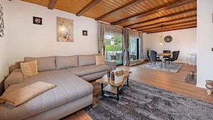 Una sala de estar con un sofá, una mesa de centro y una zona de comedor con sillas y una mesa.