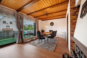 A dining area with a wooden ceiling, a dining table with chairs, a rug, and a view of the outside. - Apartment 'Bettys Home 1og' with Balcony and Wi-Fi (Gersheim)