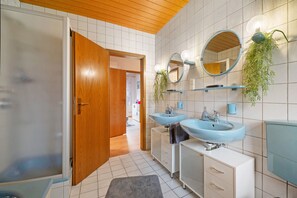 A bathroom with two sinks, a mirror, and a wooden door. - Holiday Apartment 'Bettys Home 1og' with Balcony and Wi-Fi (Gersheim)