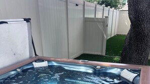 A hot tub with a wooden frame, a control panel, and a white cover.
