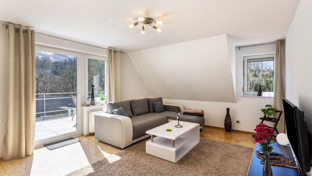 En moderne stue med sofa, sofabord og fjernsyn.