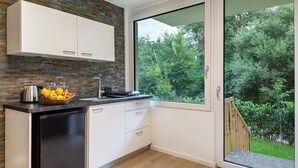 Una cocina moderna con lavavajillas, frutero y ventana con vistas a zonas verdes.