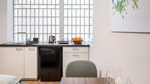 A modern kitchen with a dishwasher, a kettle, and a bowl of fruit on the counter. - Studio Apartment 'Schlatt' with Wi-Fi (Bad Krozingen)