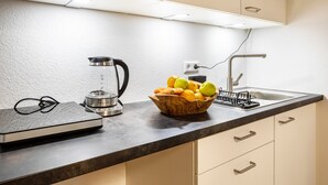 A kitchen with a coffee maker, a scale, a fruit bowl, and a sink. - Studio Apartment 'Belchen' with balcony and Wi-Fi (Bad Krozingen)