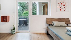 Une chambre moderne avec un lit, une fenêtre et une porte donnant sur un espace extérieur.