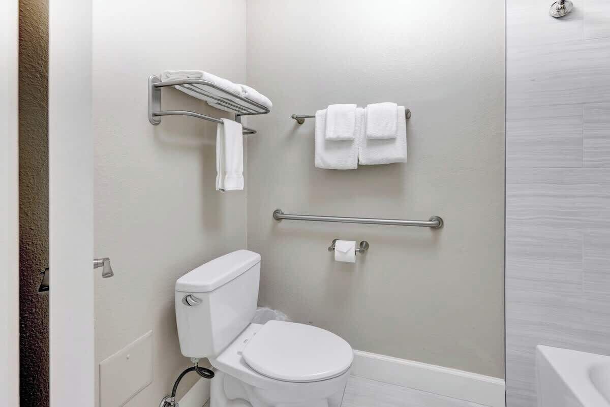 A bathroom with a toilet, a towel rack, and a grab bar.