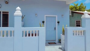 A blue house with a white door and a small balcony. - Lovely Studio Apartment in Soufriere from Claviers (Soufriere)