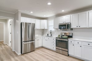 Fridge, microwave, stovetop, coffee/tea maker - Modern 3-bedroom detached space w/ WiFi, kitchen, full-size fridge, living room (Lincoln)