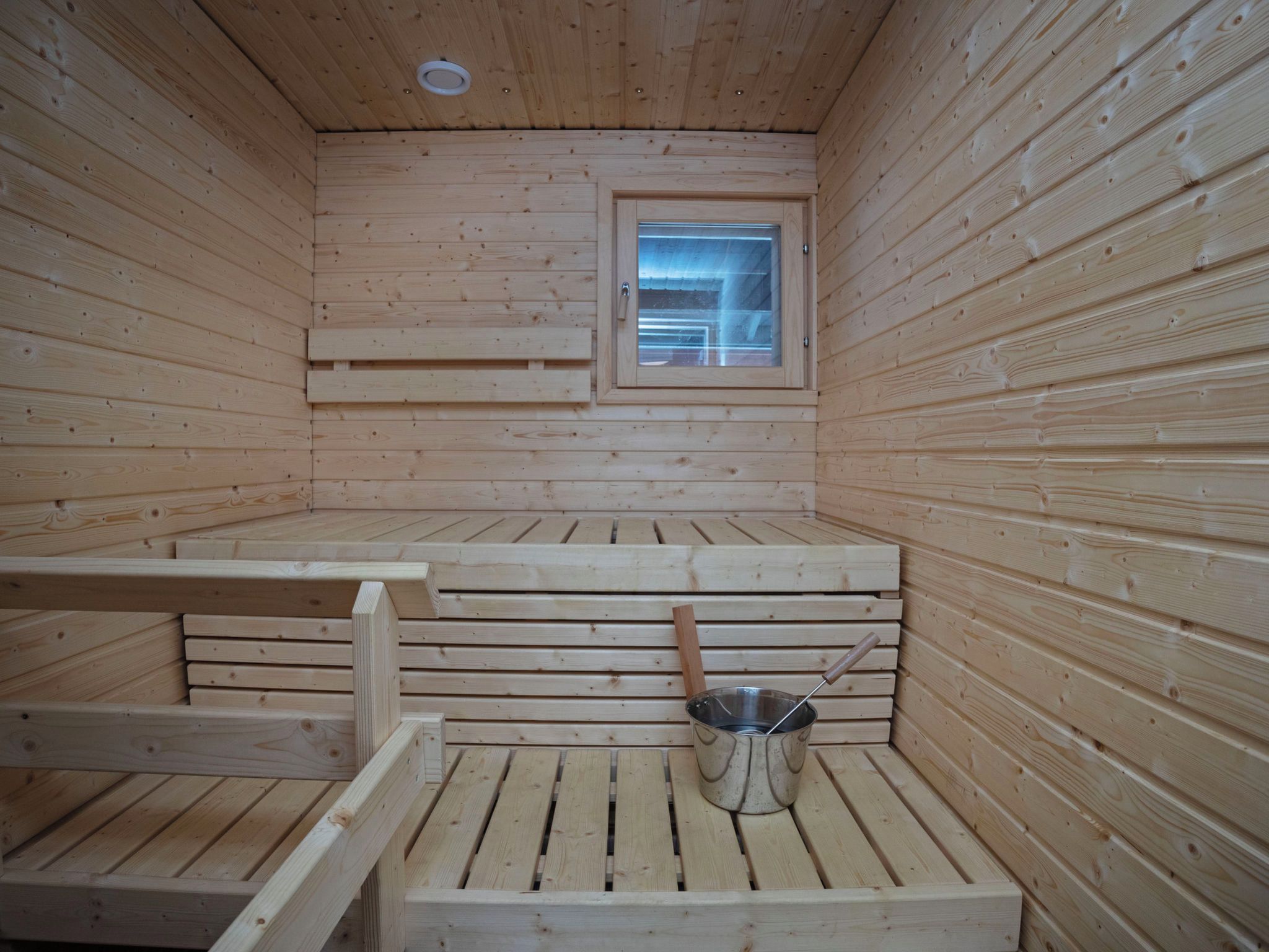A sauna room with wooden benches and a window.