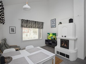 En moderne stue med pejs, spisebord og fjernsyn.