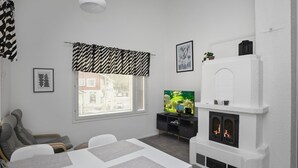 A modern living room with a fireplace, a dining table, and a TV. - Leviraitti 4 a 4 by Interhome (Kittilä)