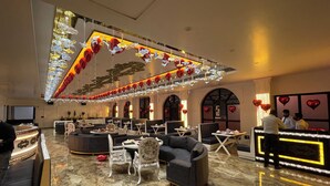 A spacious lobby with a marble floor, seating areas, and a reception desk.