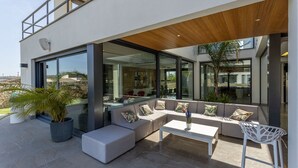 A modern outdoor living area with a sofa set, a coffee table, and a potted plant. - Modern 4 bedroom villa with pool and barbecue (Llubi)