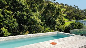 A rectangular swimming pool with a tiled edge, surrounded by a wooden deck. - Ultimate Escape in Vibrant De Waterkant at Ishani (Cape Town)