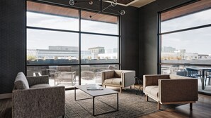 Un salon moderne doté de grandes fenêtres, d’un plafond en bois et de meubles contemporains.