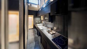 A modern kitchen with a central island, a built-in oven, and a window above the sink.