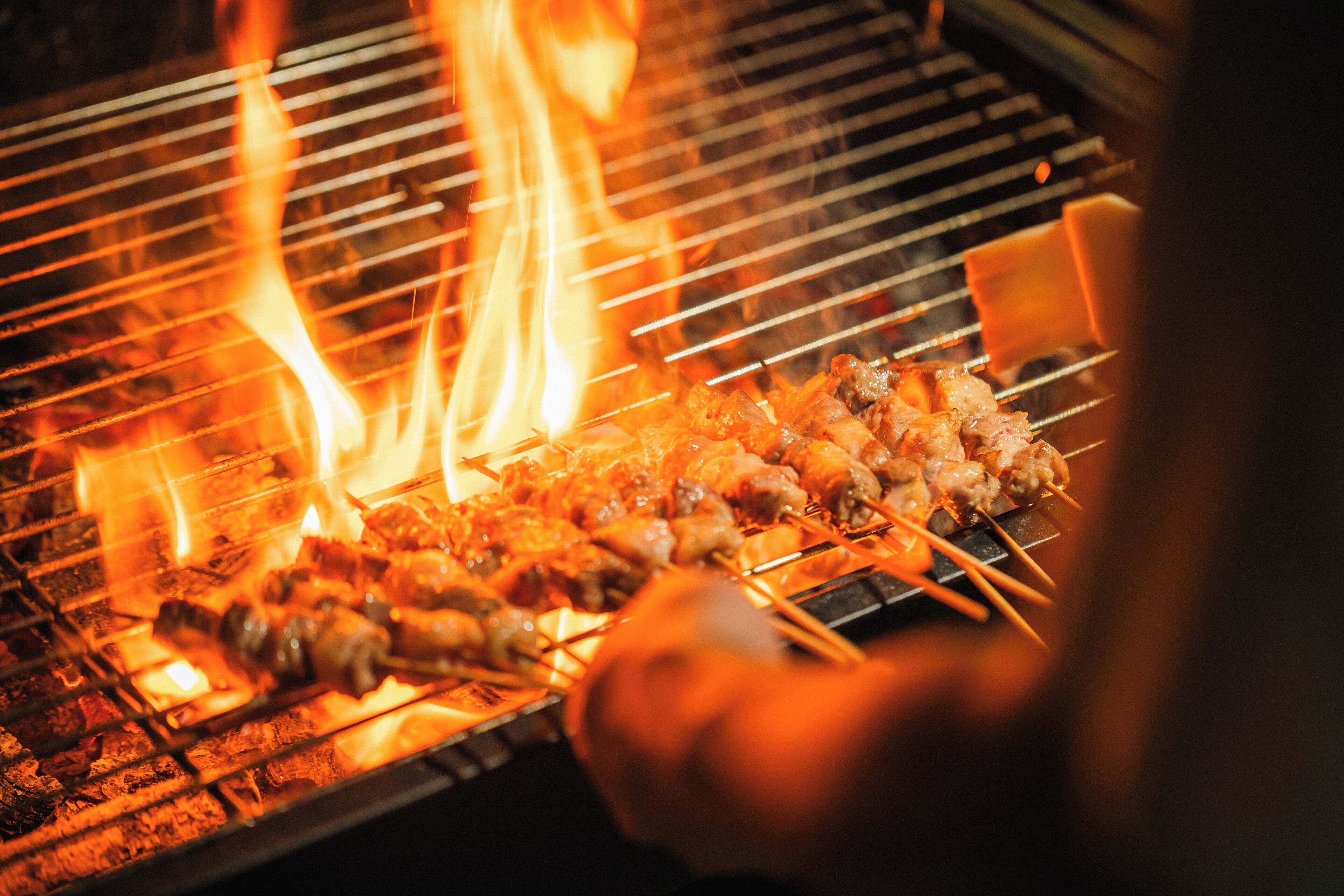A grill with skewers of meat being cooked over an open flame.