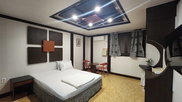 A modern bedroom with a bed, a desk, and a chair.