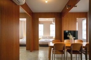 A modern hotel room with a dining area, a sofa, and a flat-screen TV. - HOTEL ReONcE Shibuya (Tokyo)