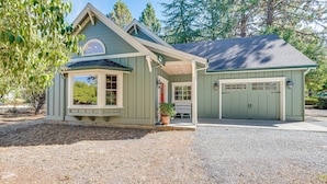Une maison à deux étages avec un porche couvert, un garage et une allée gravillonnée.