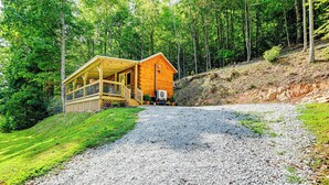 Eine Holzhütte mit Veranda, umgeben von einem Wald.