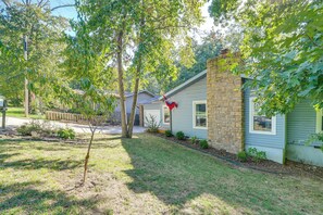 A residential house with a stone chimney, a small front yard, and a tree. - Home w/ Trail Access & Fire Pit in Bella Vista! (Bella Vista)
