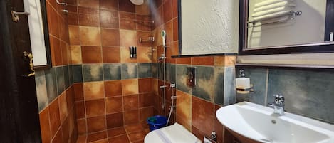 Un baño con ducha, inodoro, lavabo y un perchero para toallas.